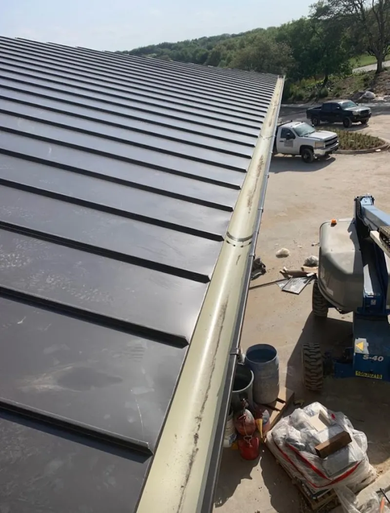 Standing seam panel and gutter detail on a metal roofing jobsite in Bel Aire